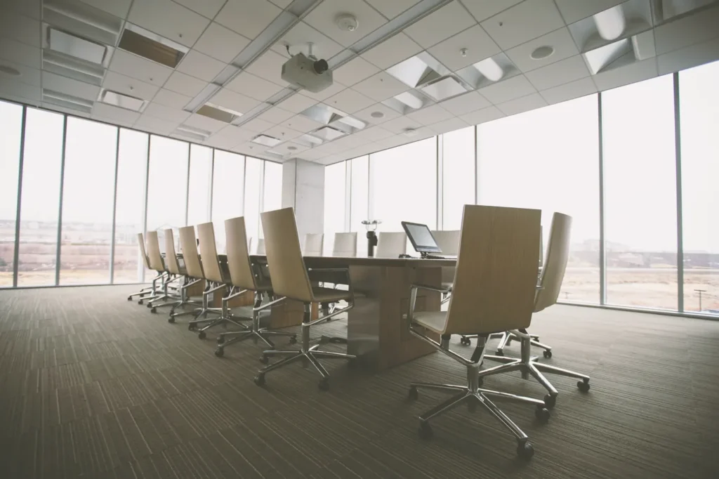 Empty boardroom with a long meeting table and floor-to-ceiling windows