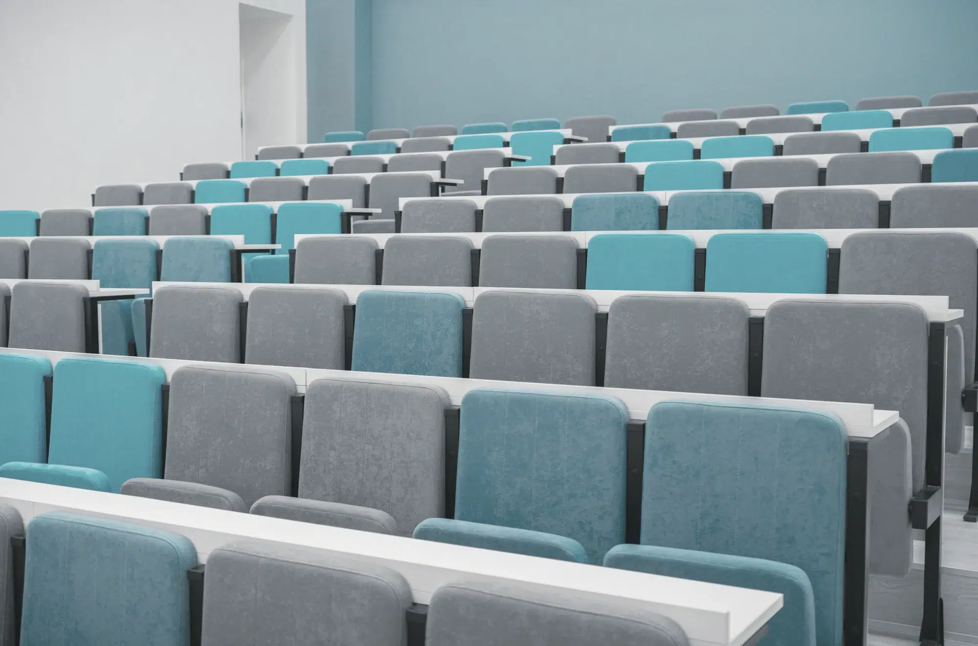 Rows of grey and teal seats in a lecture theatre